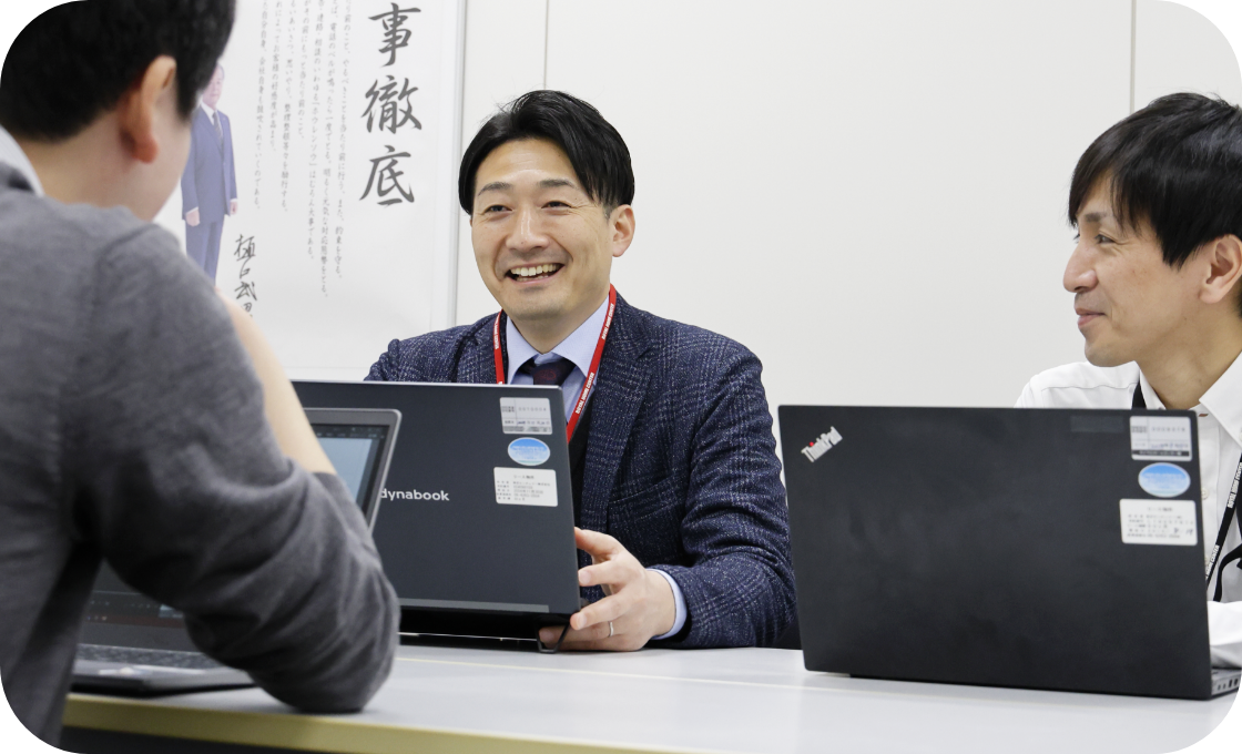 神原さんがオフィスでチームのメンバーと話している様子